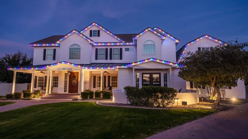 Modern home outdoor holiday lighting in purple and teal at twilight