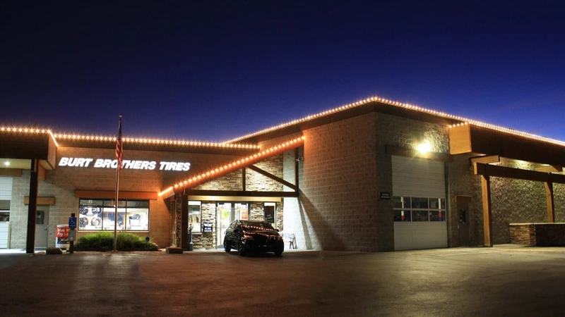 Commercial outdoor holiday lighting on a storefront at night